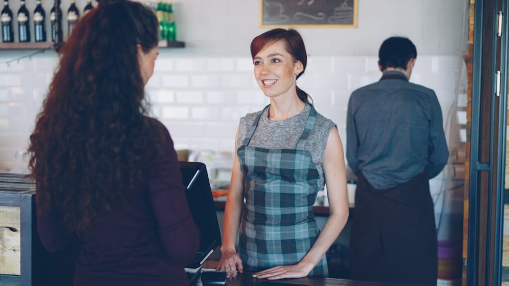 Shop employee talking with a happy customer at the counter
